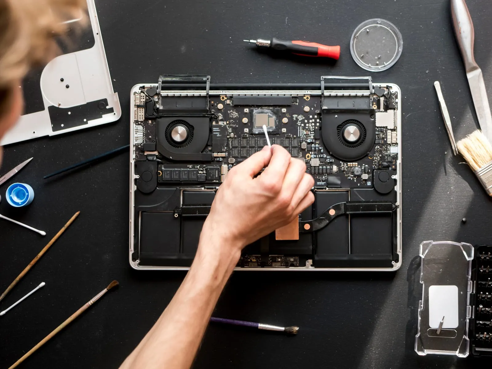 A 360 IT Support engineer working on an open laptop at the workbench